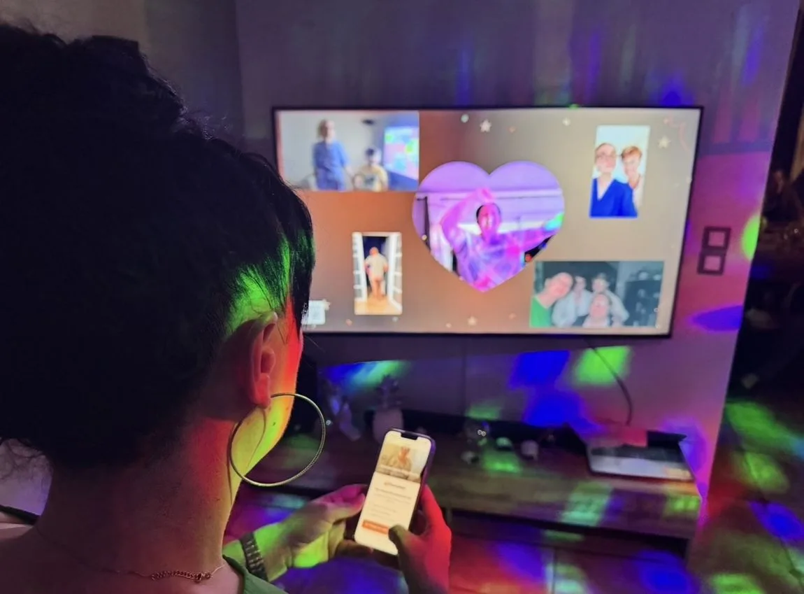 Une invitée regarde le mur MemoWall affiché sur l'écran pendant une soirée.